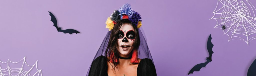 person in halloween costume holding a pumpkin